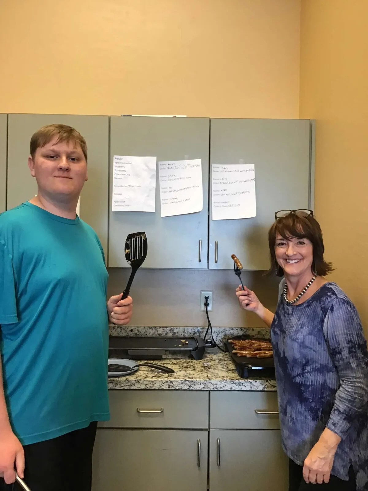 An ASCEND staff member and a student cooking together in the life-skills kitchen