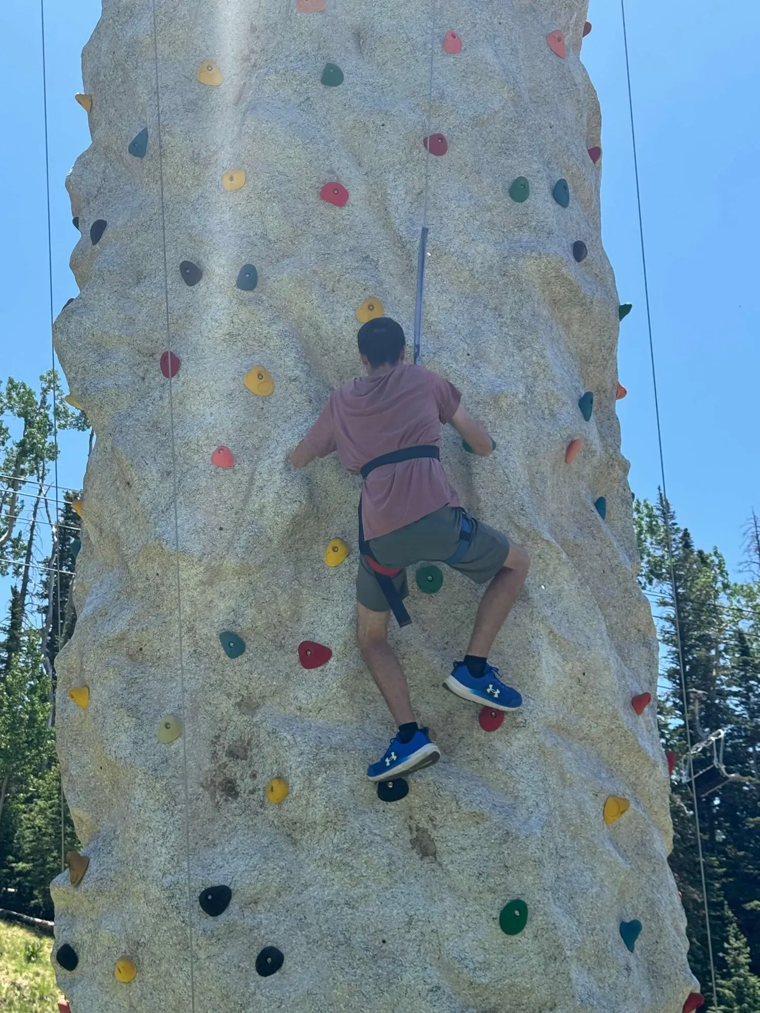 An ASCEND student climbing a rock wall on a summer outing